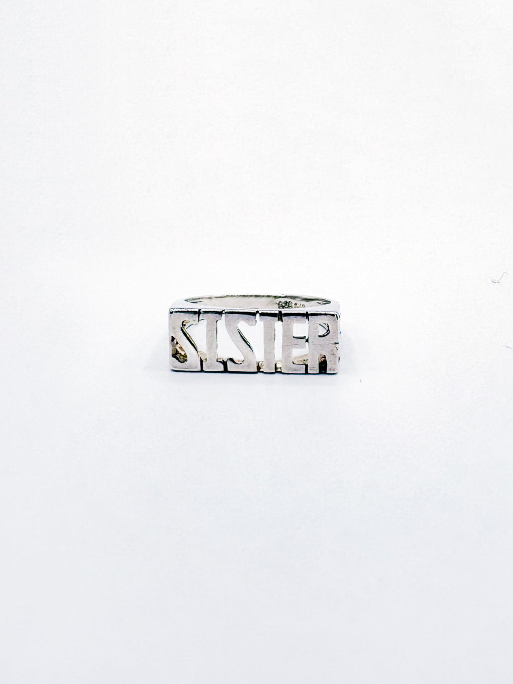 Silver ring with 'SISTER' engraving on a white background